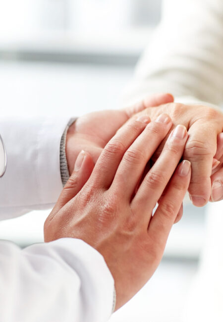 medicine, age, support, healthcare and people concept - close up of doctor or nurse holding senior man hand at hospital